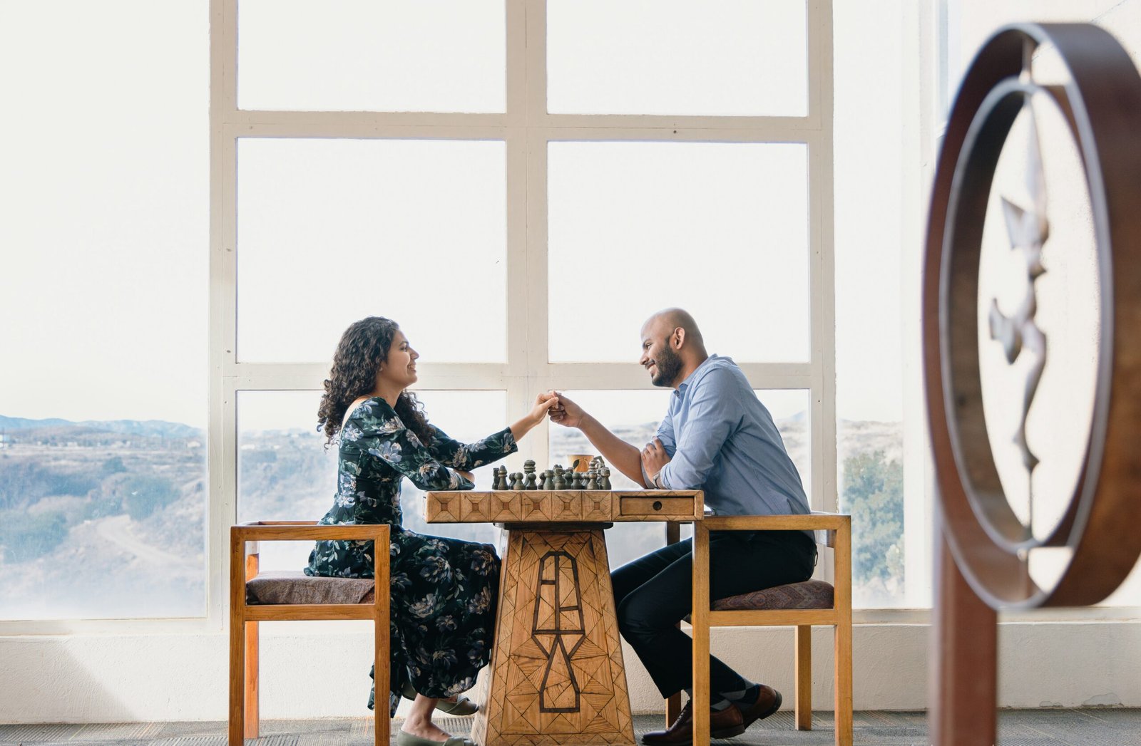 a man and woman sitting at a table playing chess